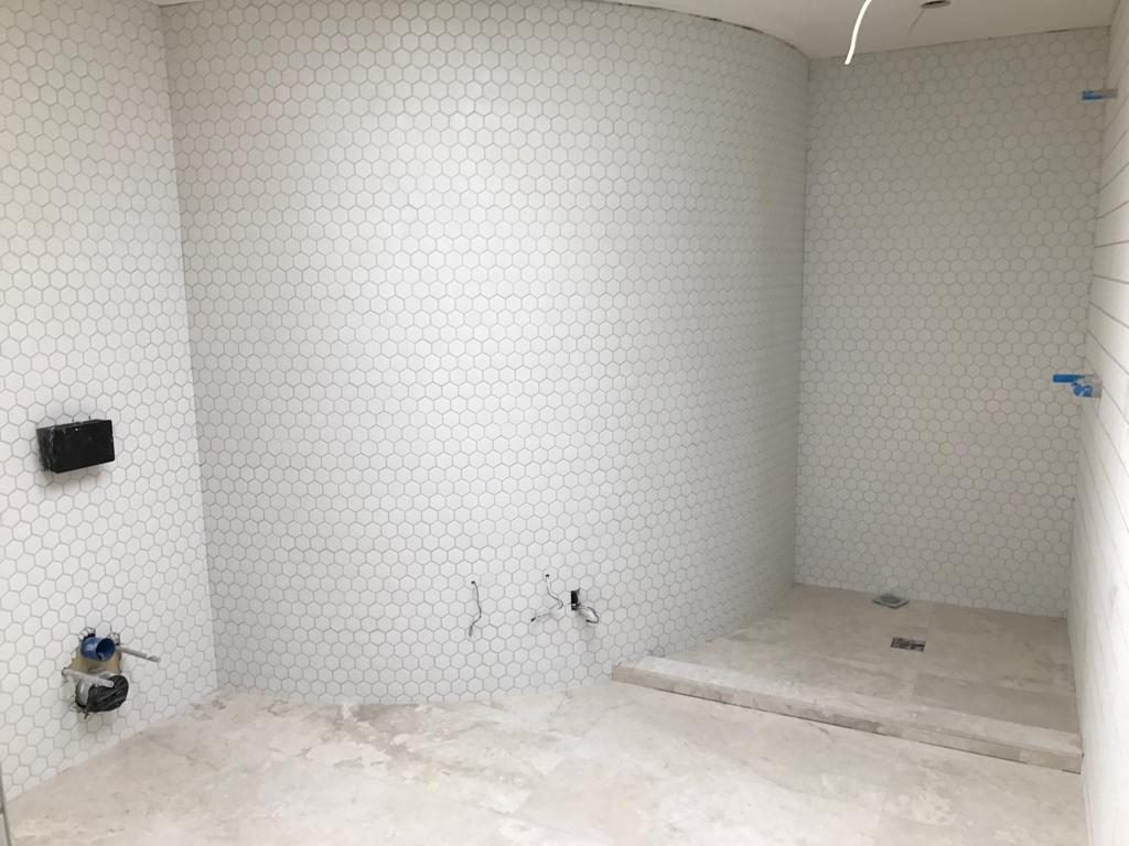 Curved wall tiled in white hexagon mosaic