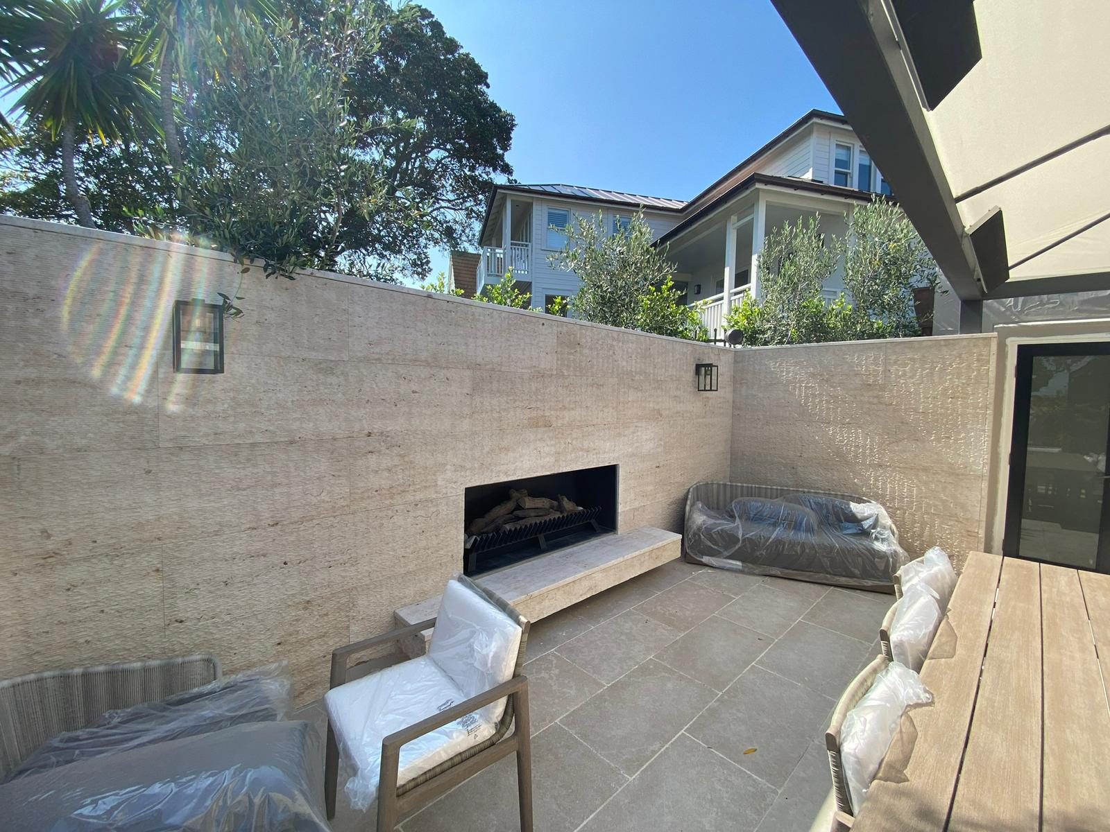 Travertine-clad outdoor courtyard with built-in fireplace