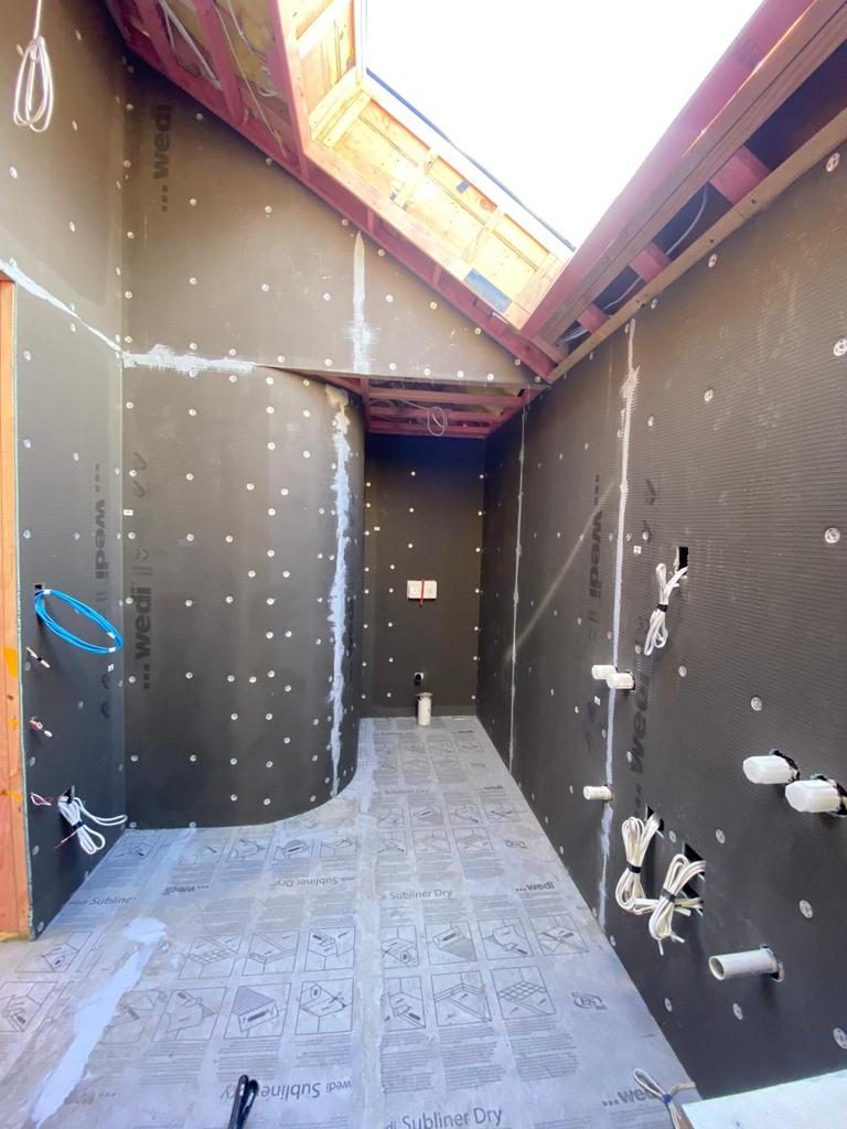 Curved Wedi waterproof board wall with Subliner Dry floor membrane before tiling